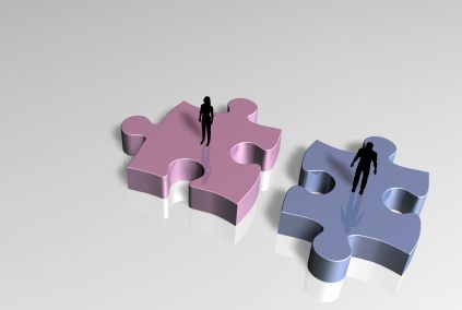 man and woman standing on puzzle pieces 