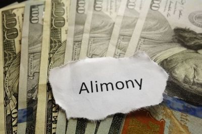 alimony on a piece of paper on top of one hundred dollar bills