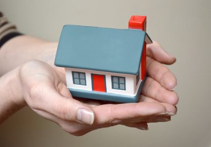 little house in the palm of a woman's hands